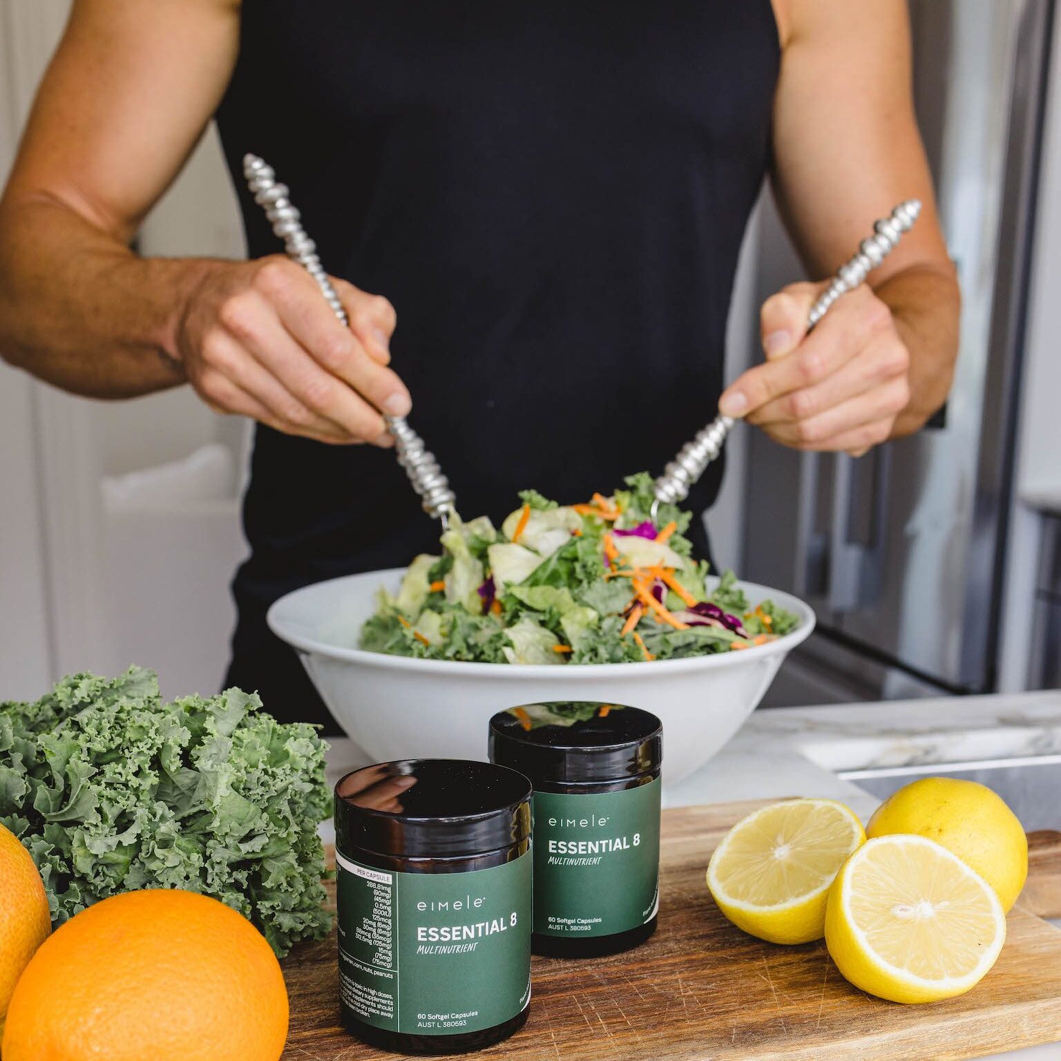 eimele lifestyle pic - muscular man with delicious salad and eimele Essential 8 multinutrient on wooden bench