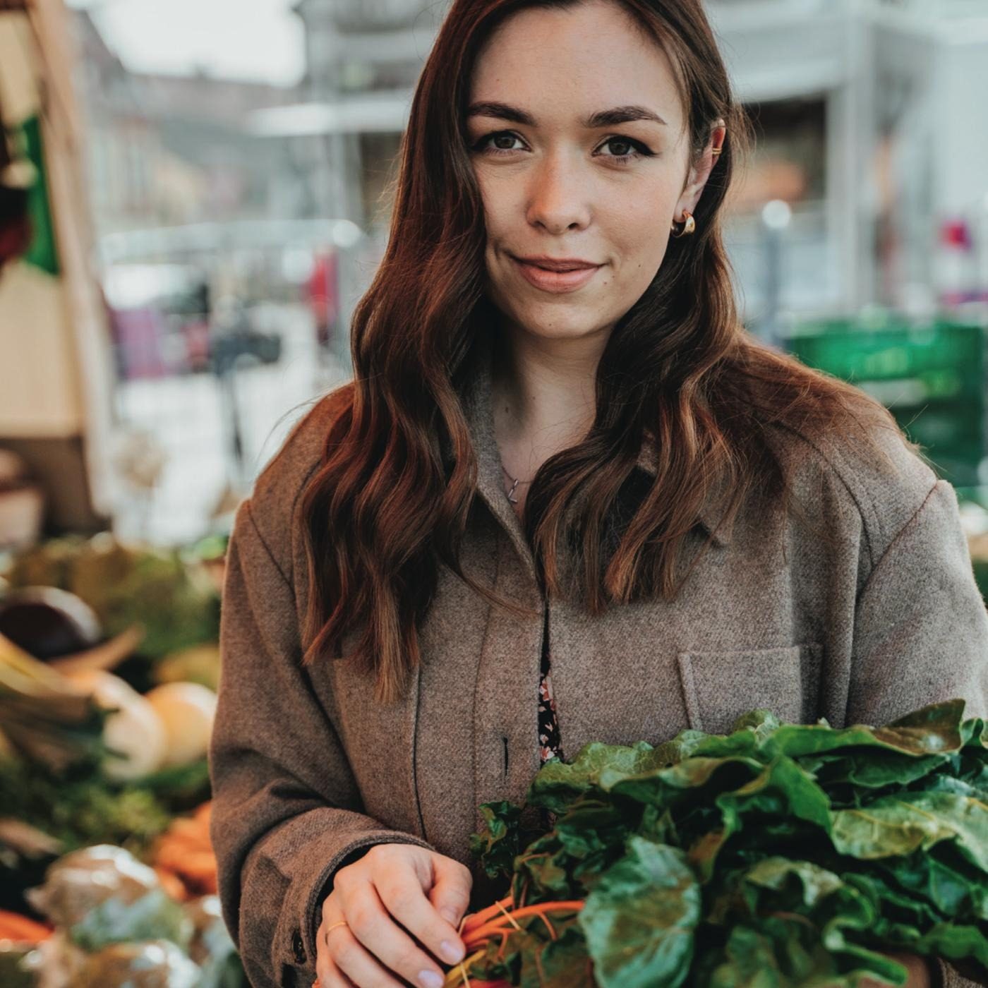 Woman at greengrocers buying healthy whole plant foods